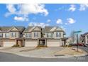 Street view of townhomes with two-car garages, showcasing the community setting and landscaping at 5806 Glassport Ln, Charlotte, NC 28210