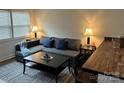 Cozy living room featuring a gray sectional sofa and a wood coffee table at 6017 Milhaven Ln, Charlotte, NC 28269