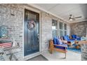 Charming front porch featuring brick accents, comfortable seating, and a welcoming wreath on the front door at 109 Belfry Loop, Mooresville, NC 28117