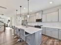 Modern kitchen featuring gray cabinets, quartz countertops, stainless steel appliances, and a large center island with seating at 114 Marron Dr, Indian Trail, NC 28079