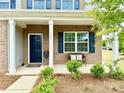 Inviting front porch with brick facade, blue door, and stylish outdoor seating at 121 Mackinac Dr, Mooresville, NC 28117