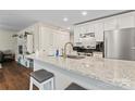 Modern kitchen with white cabinets, granite countertops, and stainless steel appliances at 209 S Gregory St, Lancaster, SC 29720