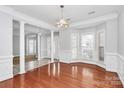 Dining room featuring hardwood floors, large windows, elegant pillars, and modern lighting at 2327 Axford Ln, Matthews, NC 28105