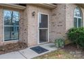 Inviting brick home entrance with a charming welcome mat and a secure screen door at 298 Upper Stanley Rd, Stanley, NC 28164