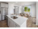 Bright kitchen boasts a large island with quartz countertop and stainless steel appliances, flowing into an adjacent dining area at 3016 Finchborough Ct # 229, Charlotte, NC 28269