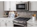 Close-up of the kitchen featuring stainless steel oven/cooktop and stylish backsplash at 3038 Finchborough Ct # 234, Charlotte, NC 28269