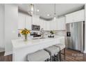 Modern kitchen featuring a quartz countertop island with seating, stainless steel appliances, and ample white cabinetry at 3038 Finchborough Ct # 234, Charlotte, NC 28269