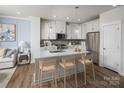 Bright kitchen boasts white cabinetry, stainless steel appliances, an island with seating, and stylish pendant lighting at 3038 Finchborough Ct # 234, Charlotte, NC 28269