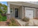 Front entry of townhome with stone accents and a black front door at 33 Woodsdale Se Pl, Concord, NC 28025