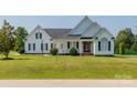 White house with gray roof, landscaping, and a spacious lawn at 3624 Ramsey Rd, Sharon, SC 29742