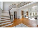 Elegant foyer with hardwood floors, grand staircase with iron railing, and view into the living area at 4316 Mourning Dove Dr, Matthews, NC 28104