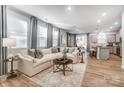 Sunlit living room featuring a plush sectional sofa, stylish decor, and an open layout connected to the kitchen at 624 Cassidy Ct, Clover, SC 29710