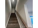 Carpeted stairway with wooden handrail leading to the upper level of the house at 624 Cassidy Ct, Clover, SC 29710