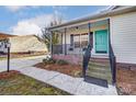 Inviting covered front porch with a seating area and a bright turquoise front door at 776 Washington Ln, Kannapolis, NC 28083