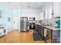 Open kitchen area with stainless steel appliances, light countertops, tile backsplash and hardwood floors at 780 N Davidson St, Charlotte, NC 28202