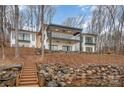 Lakefront home with stone retaining wall and stairs to dock at 8092 Edgewater Dr, Norwood, NC 28128