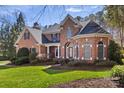 Charming brick home with lush landscaping, arched windows, and covered entryway at 1016 Antioch Woods Ln # 36, Weddington, NC 28104