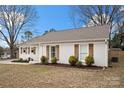 Attractive single-story home boasting white brick, wooden shutters, and a well-maintained front lawn at 11400 Five Cedars Rd, Charlotte, NC 28226