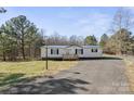 Inviting single-story residence showcasing a well-manicured lawn and a gravel driveway at 145 Morcroft Ln, Cleveland, NC 27013