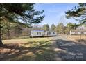 Scenic view of a single-story home surrounded by lush trees and a spacious front yard at 145 Morcroft Ln, Cleveland, NC 27013