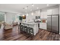 Open-concept kitchen featuring an island with seating, stainless steel appliances and hardwood floors at 16022 Red Buckeye Ln, Huntersville, NC 28078