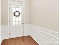 Inviting entryway with wood floors, white wainscoting and a front door with glass panels at 17563 Hawks View Dr, Fort Mill, SC 29707