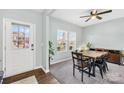 Bright dining room with a modern table set, a ceiling fan, and a large window with natural light at 191 Sutters Mill Dr, Troutman, NC 28166