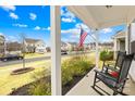 Inviting front porch with rocking chairs, an American flag, and meticulously maintained landscaping at 191 Sutters Mill Dr, Troutman, NC 28166