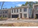 Two story home with stone and stucco exterior, glass garage door, and brick driveway at 220 Ambleside Village Ln, Davidson, NC 28036