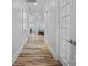 Bright hallway with hardwood floors, white trim, and doors leading to living spaces at 220 Ambleside Village Ln, Davidson, NC 28036