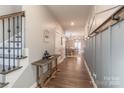 Inviting hallway with hardwood floors, coat rack, and staircase, leading to the dining room at 3575 Cerelia Ln, Denver, NC 28037