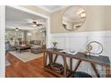 Bright foyer area showcasing hardwood floors, a decorative table, and an open view to the cozy living room at 3939 Sussex Ave, Charlotte, NC 28210