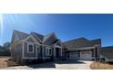 Beautiful single-story home showcasing a neutral color palette, inviting facade, and attached three-car garage at 6098 Ballard Rd, Denver, NC 28037