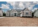 Charming gray home with white trim, double-door entry, stone accents, and attached two-car garage at 6098 Ballard Rd, Denver, NC 28037