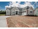 Charming gray home with white trim, double-door entry, stone accents, and attached two-car garage at 6098 Ballard Rd, Denver, NC 28037