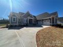 Attractive one-story home featuring an attached garage, neutral siding, and a long concrete driveway at 6098 Ballard Rd, Denver, NC 28037