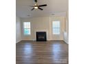 Bright living room featuring a modern ceiling fan and fireplace at 6140 Whispering Brook Ct, Charlotte, NC 28216