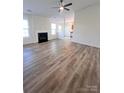 Open-concept living room featuring hardwood floors and a fireplace at 6140 Whispering Brook Ct, Charlotte, NC 28216