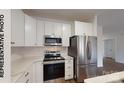 Modern kitchen featuring white cabinets, stainless steel appliances, and marble countertops at 709 Queens Ct, Gastonia, NC 28052