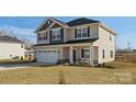 Charming two-story home with a covered front porch, two-car garage and manicured lawn at 821 Bethesda Rd, Statesville, NC 28677