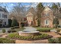 Charming brick home with a circular driveway and a lovely water fountain feature in the front yard at 8928 Heydon Hall Cir, Charlotte, NC 28210