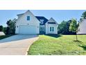 Cream-colored two-story home boasting a lush green lawn, an attached two-car garage and a welcoming front entrance at 136 Autumn Blaze Rd, China Grove, NC 28023