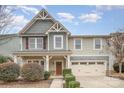 Traditional home showcasing detailed trim, a cozy porch, and an attached two-car garage at 2201 Bluebell Way, Tega Cay, SC 29708
