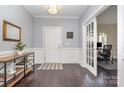 Inviting foyer with hardwood floors, wainscoting, and an adjacent office with french doors at 2201 Bluebell Way, Tega Cay, SC 29708