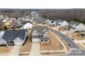 Wide aerial view of a gray two-story home in a neighborhood with sidewalks and mature trees on a sunny day at 3041 Winged Teal Ct # 57, Belmont, NC 28012