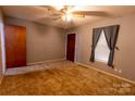 Comfortable bedroom with a ceiling fan, window with curtains, and closet door at 3581 Thompson St, Newton, NC 28658
