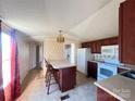 Eat-in kitchen with island, appliances, and dark wood cabinets at 3610 Becky Ln, Monroe, NC 28112