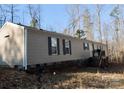 Side exterior view of a single-story home with tan siding and black shutters at 5122 Wrenn Dr, Denver, NC 28037