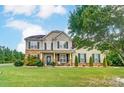 Charming two-story home featuring stone accents, a manicured lawn, and inviting front porch at 712 Springwood Dr, Waxhaw, NC 28173