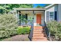 Inviting front porch with brick steps, hanging plants, and stylish door at 1304 Armstrong Ford Rd, Belmont, NC 28012